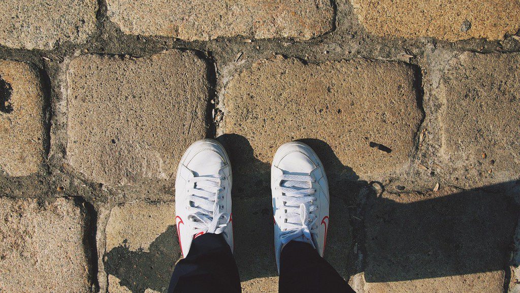 A person standing on the ground with their feet up.