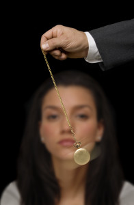 A woman is holding up a gold pocket watch.