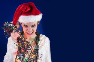 A woman wearing a santa hat and christmas lights.