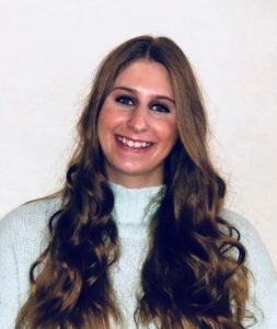 A woman with long hair smiling for the camera.