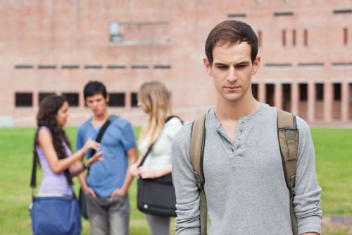 A man with backpack standing in front of other people.