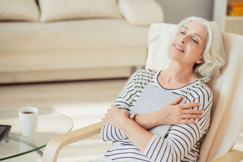 A woman sitting in a chair with her arms crossed.